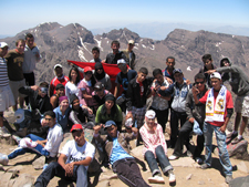 Peace Corps volunteers Peter Kitlas and Anna James pose with C.L.I.M.B. participants on the summit of Mt. Toubkal.