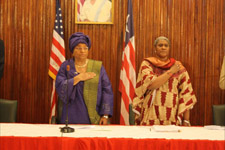  President Sirleaf and Minister of Foreign Affairs King-Akerele standing during the singing of the Liberian national anthem.