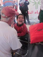 Peace Corps/Morocco volunteer Jim Stewart congratulates a Special Olympic athlete who completed a 50-meter race.