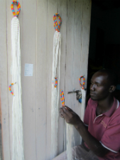 A Ugandan student works on a hammock.