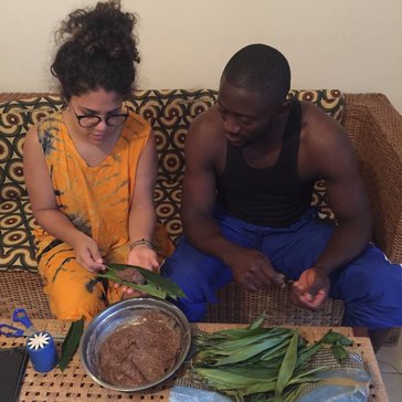 A Puerto Rican woman and Cameroonian man sit on a couch, cooking together
