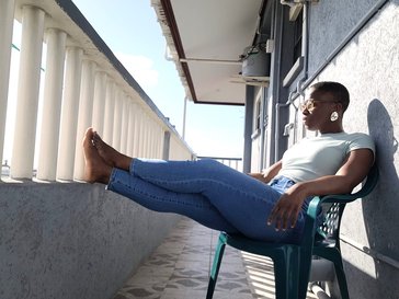 Volunteer chanel rigby sits on a chair outside in guyana