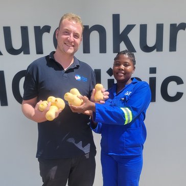 Jacob and community member Elina show off harvests from the clinic garden in Namibia.