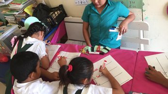 One teacher watching three students write