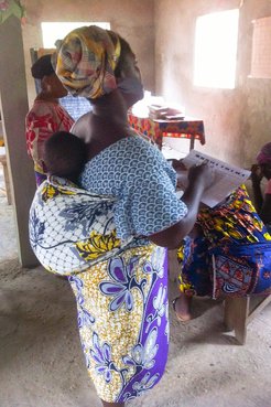 A Beninese "mama" practicing accounting with her baby.