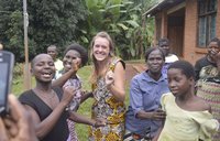 Health Volunteer Emma celebrates her return to Malawi with her community by dancing