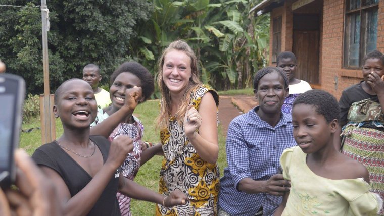 Health Volunteer Emma celebrates her return to Malawi with her community by dancing