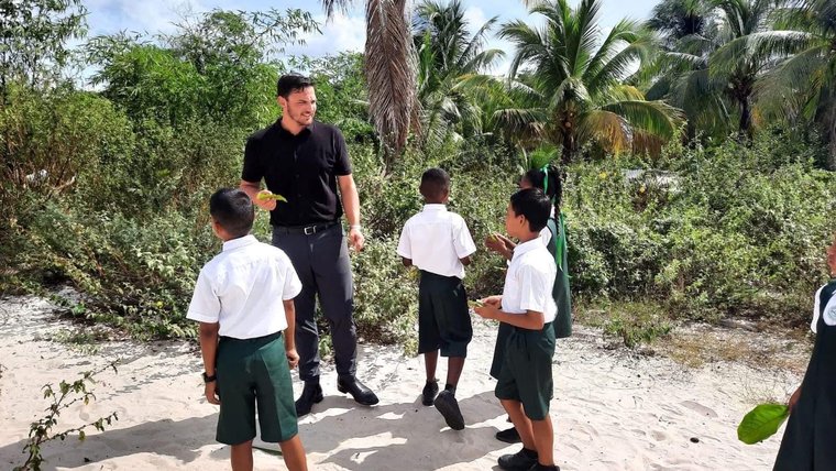 Chance and students take science class outdoors in Guyana.