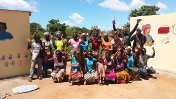 Blonde White American celebrates with Mozambican friends, colleagues and community members.