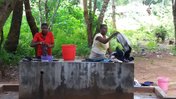 Two Malawian women wash clothes at a borehole