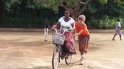 An older female Volunteer teaches a older Malawian female how to ride a bike