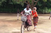 An older female Volunteer teaches a older Malawian female how to ride a bike