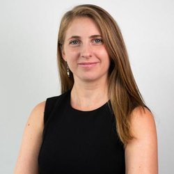 A young, white woman smiles at the camera in a professional head shot.