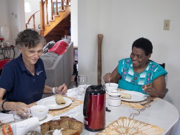 volunteer and host mother eating a meal at the table