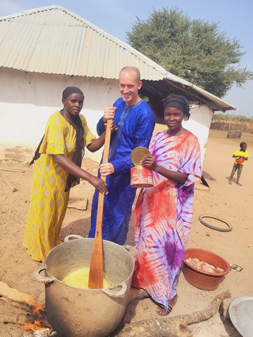 Sean helps cook a meal for the naming ceremony (pembagual) of his host sister in The Gambia.