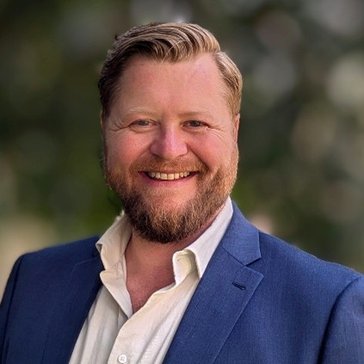White male person smiles at the camera