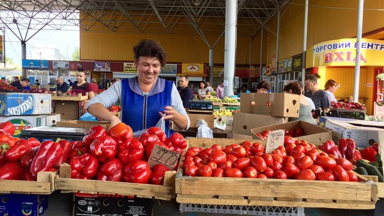 A woman selling tomatoes and peppers at the bazaar.