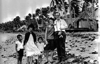 A Volunteer in 1964 stands with her visiting father in the Philippine village.