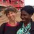 A white, female Volunteer over 50 years of age smiles next to a Malawian woman.
