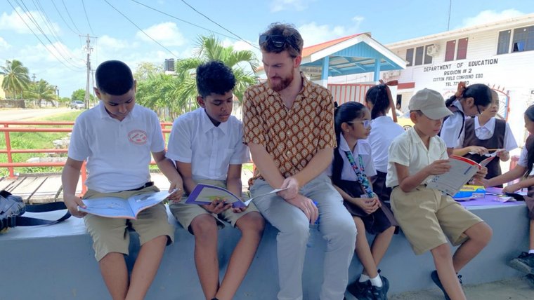 Thaddeus at an outdoor literacy event with Guyanese students.