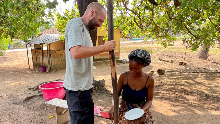 A Volunteer working with a community member to make cana in Sierra Leone.