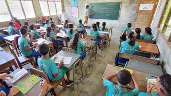 Volunteer teaches children in classroom