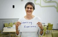 Grete is holding sign "learning experience"