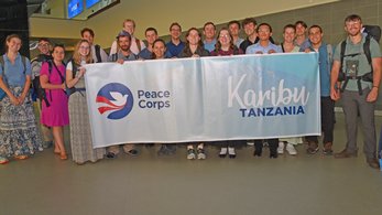 Group of trainees pose with Tanzania banner.