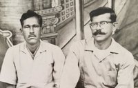 A Peace Corps Volunteer in 1965 sits with a community member.