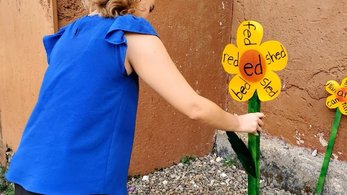 Peace Corps Jamaica Volunteer Posing Next to the New Literacy Garden