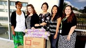 IWG handing over donation to Peace Corps Volunteer and Director