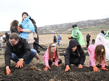 Peace Corps Moldova community members are planting trees in the field