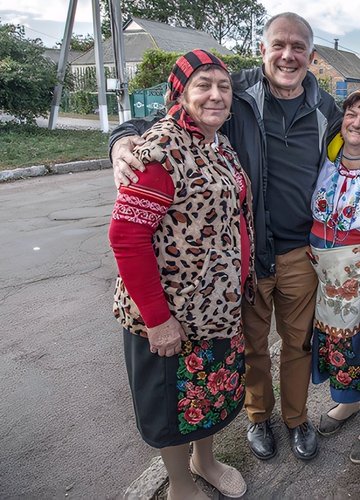A white American male stands with his Ukrainian friends outside on a road