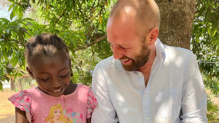 Volunteer reading with a young girl in Sierra Leone.