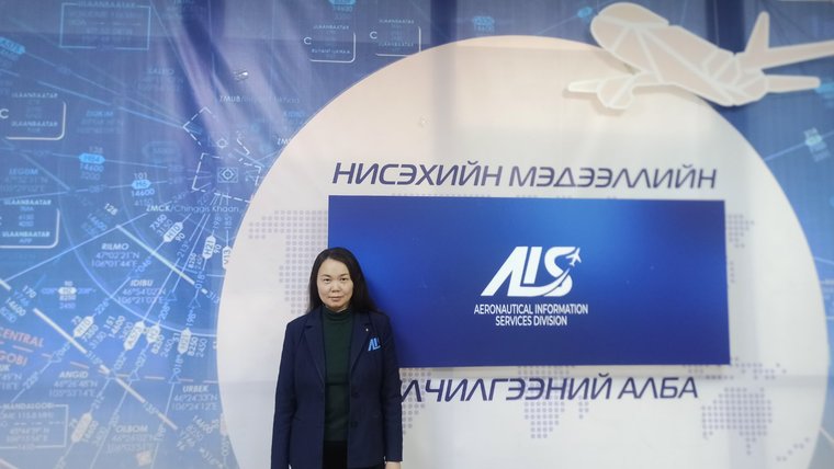 A Mongolian woman stands in front of an airline logo