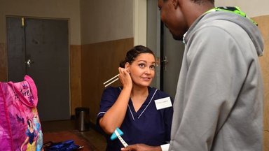 A female nurse talks to a tall male patient