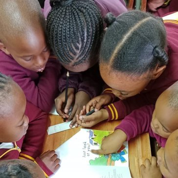 Children around a table reading.