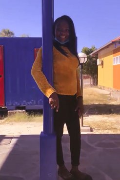 One Namibian woman poses by a building pillar