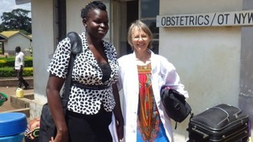 Two women stand in front of an obstetrics office