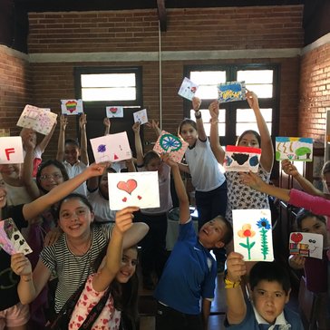 Members of the Art Club at the Escuela Basica show off their finished drawings/paintings.