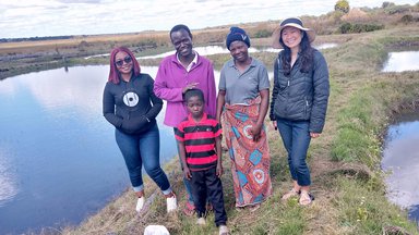 Fish farmer with family and PCV