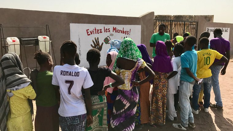 Badara Drame instructs the children on the importance of handwashing.jpg