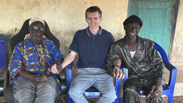 Jace with El Hadj (left) and Fodé (right), two members of his host community during Jace's 'baptême', a traditional ceremony for Jace's adoption of a local name.