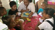Teacher reading a book to group of students