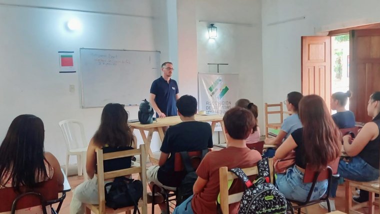 Volunteer Ben D. standing in front of a class teaching.
