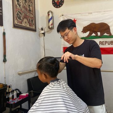 Ben learns to style hair at his host brother’s barbershop.