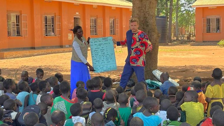 Benjamin and his supervisor Kalenda and conduct a reading lesson at a school in Uganda.