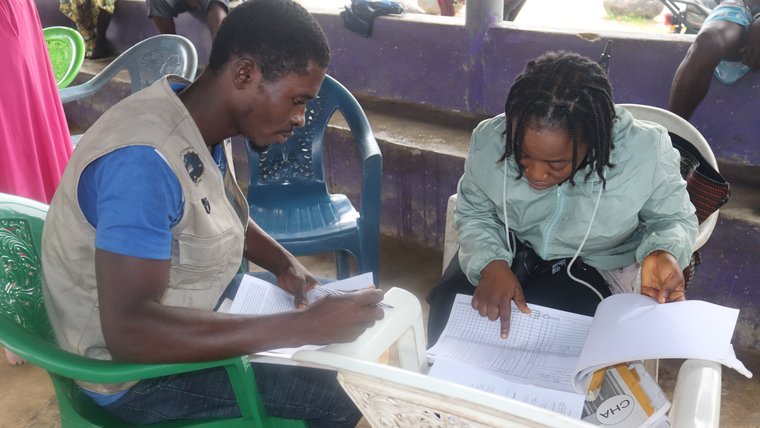 Bintu reviews a medical record book in a catchment community.