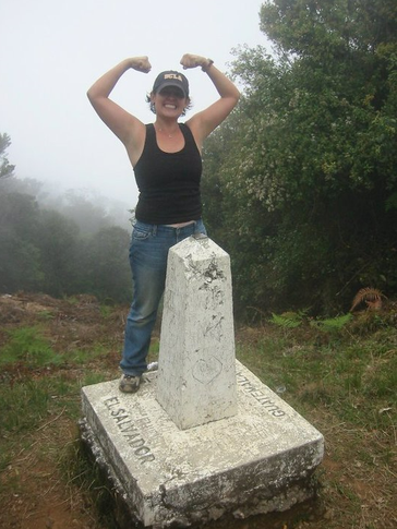 A female Volunteer poses at Guatemala-El Salvador border