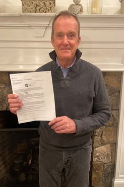 Bryan Lynch holds his invitation for peace corps service